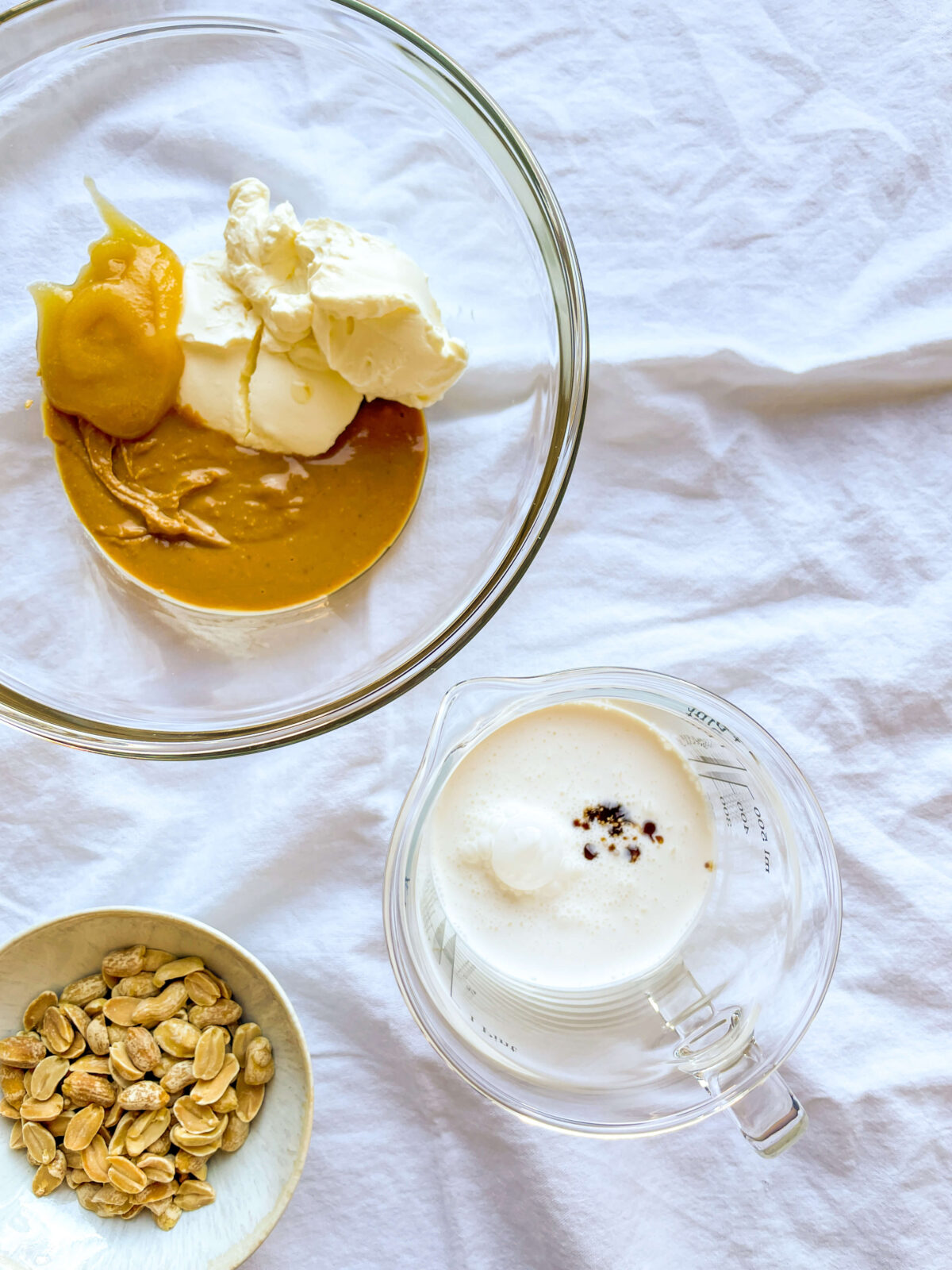 Image shows the ingredients required to make a Chocolate PB mousse: heavy whipped cream, honey, real vanilla extract, cream cheese, natural sugar-free peanut butter, salt, unsweetened chocolate, roasted peanuts.