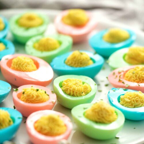 colored easter deviled eggs on a platter