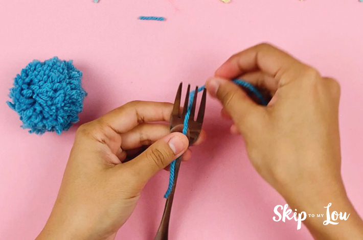 Wool wrapped around a fork to start the second method of making a pom pom.