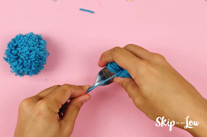 The fork is pulled away from the pom pom.