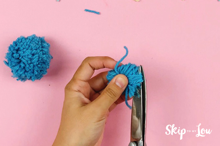 The tied ends of the pom pom are now cut.