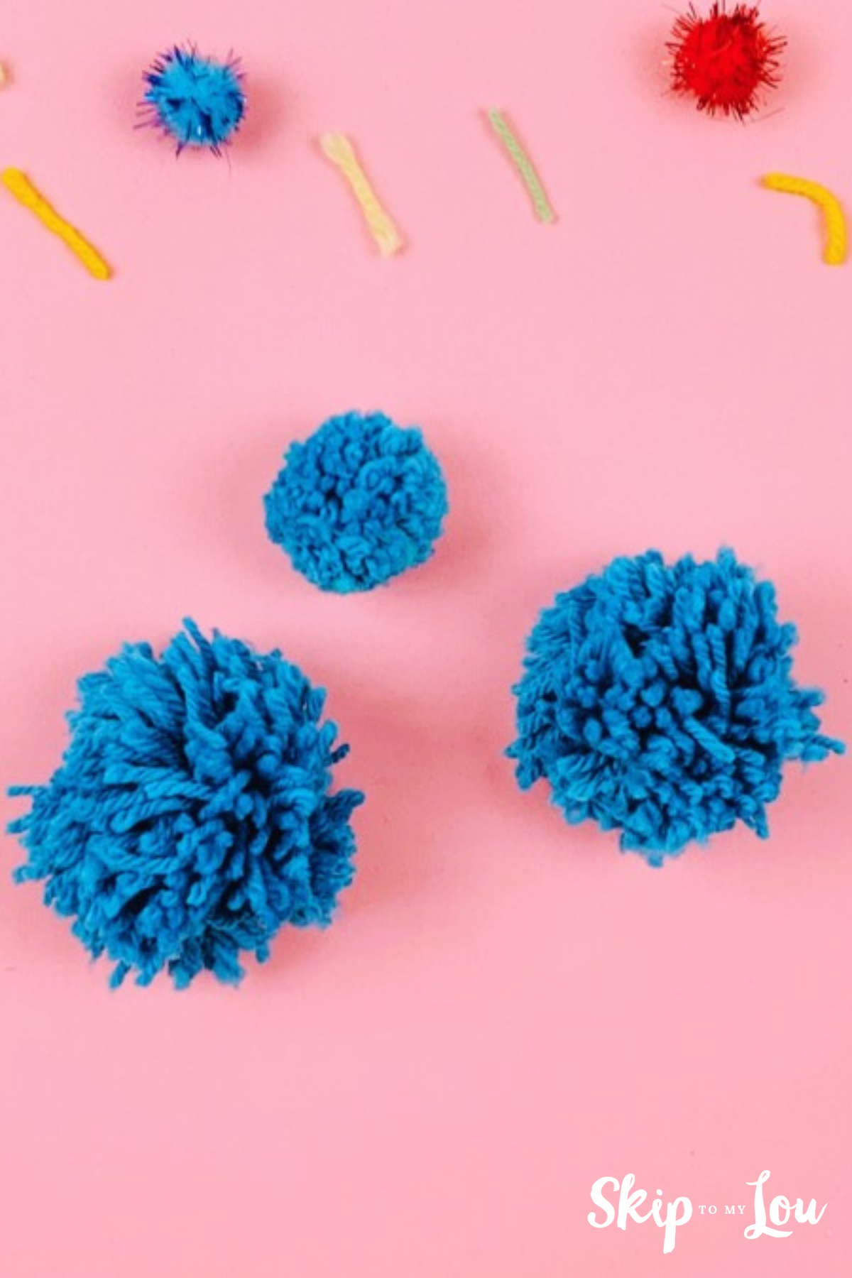 Blue pom poms on a pink background
