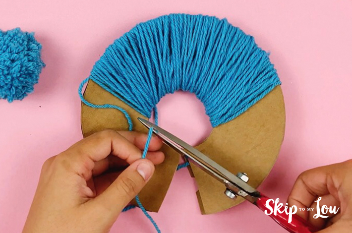 The remaining ball of wool is cut free from the cardboard.