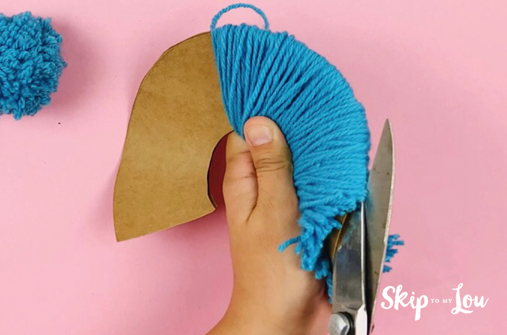 The wool at the end of the cardboard is cut in harlf.