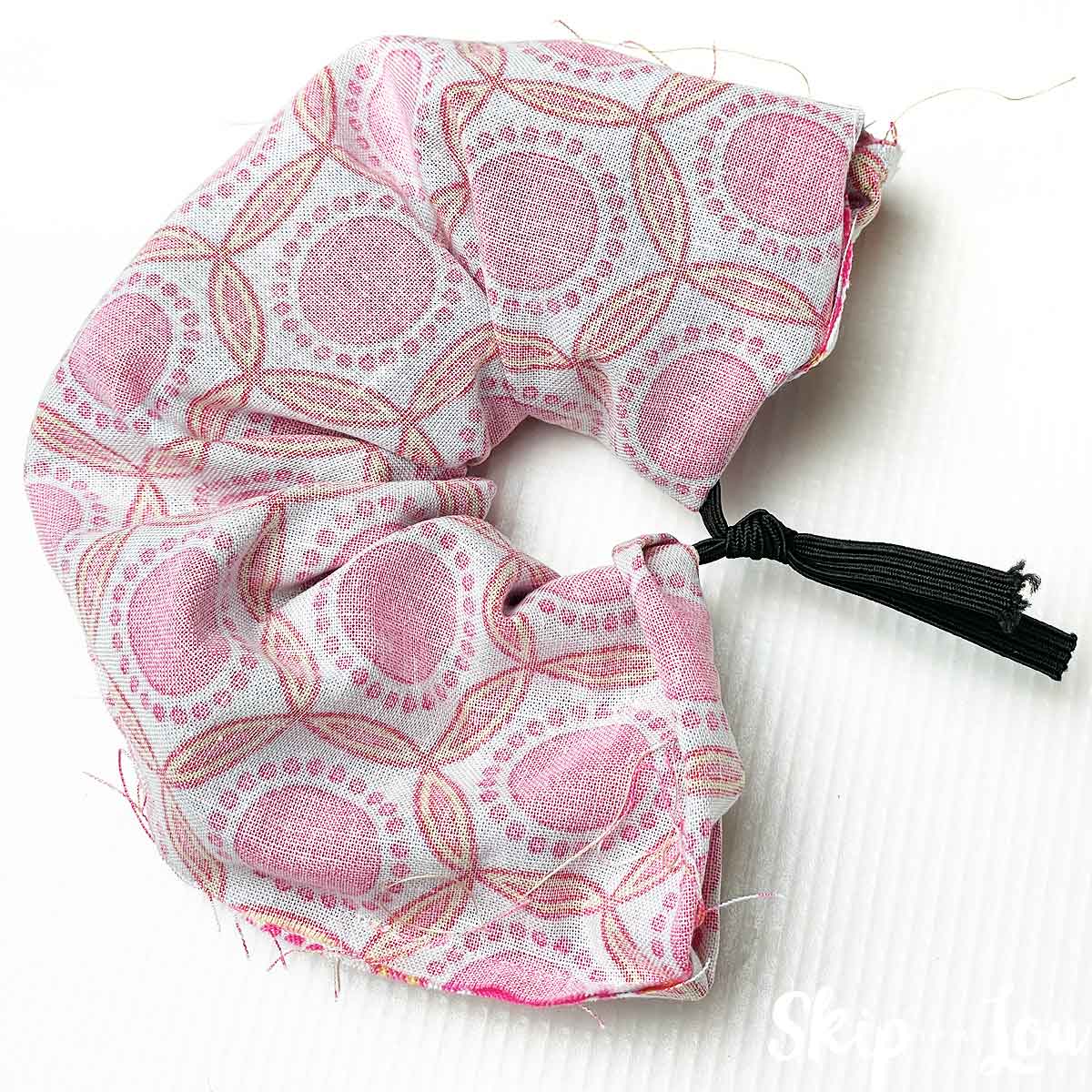 feel a piece of elastic through the center of the sewn piece and tie a knot in the elastic.