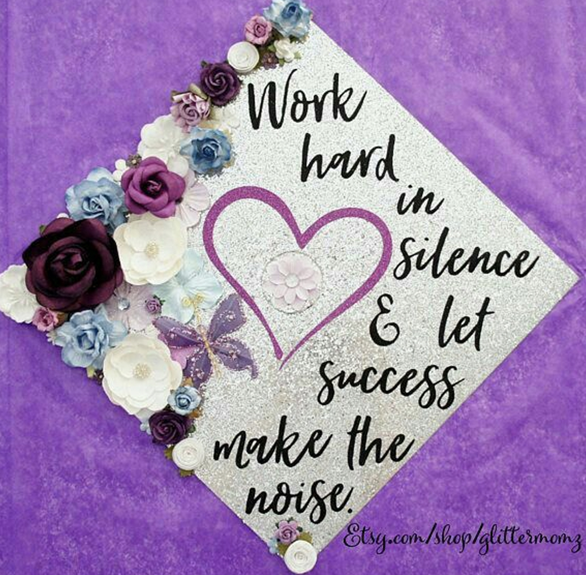 Silver graduation cap with a quote that reads "work hard in silence & lett success make the noise"