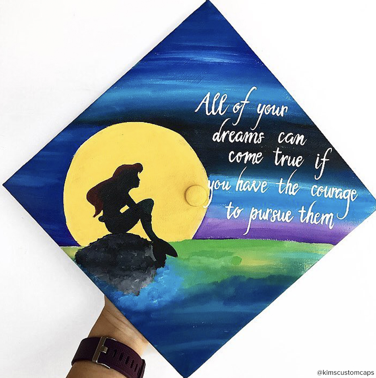 Graduation cap with a The Little Mermaid quote that says "all of your dreams can come true if you have the courage to pursue them"