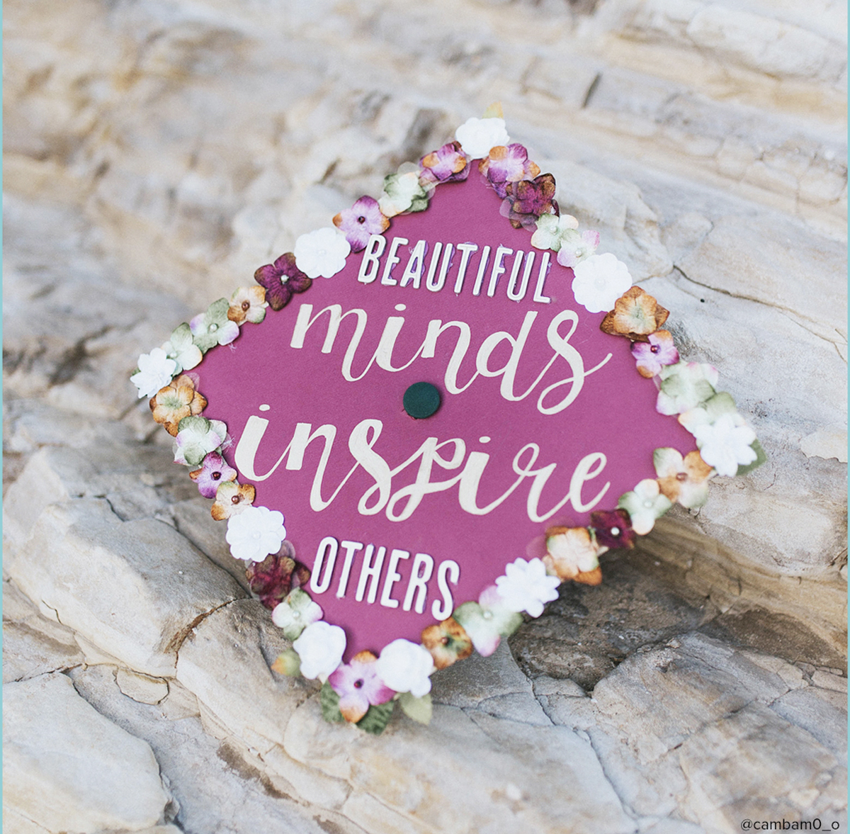 Pink graduation cap with quote that says "beautiful minds inspire others"