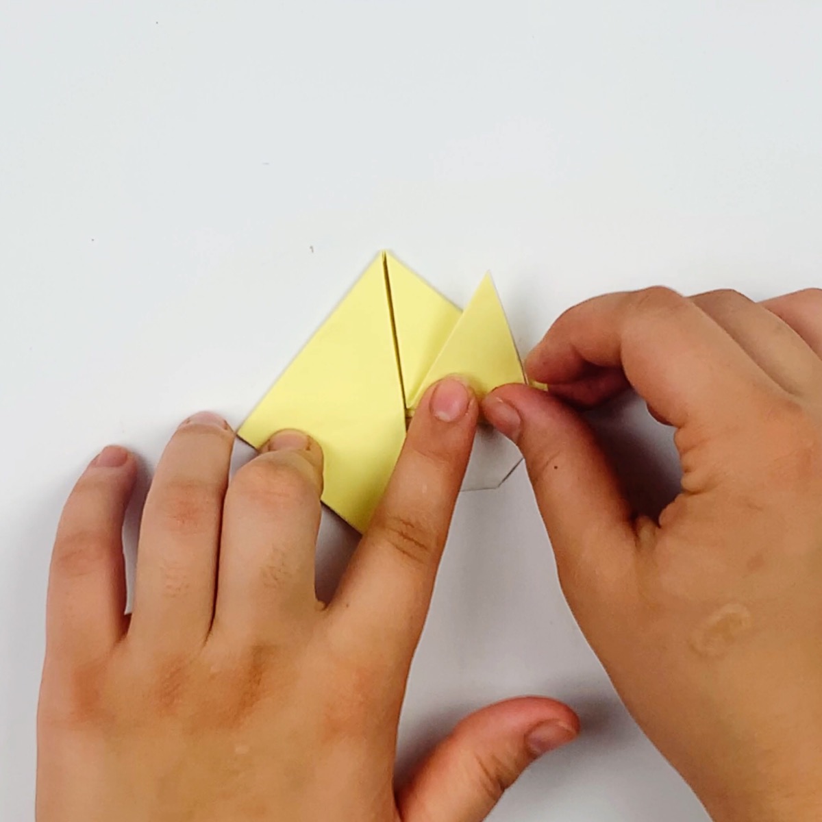 The points of the flaps are then folded back up to form the origami cat's ears.