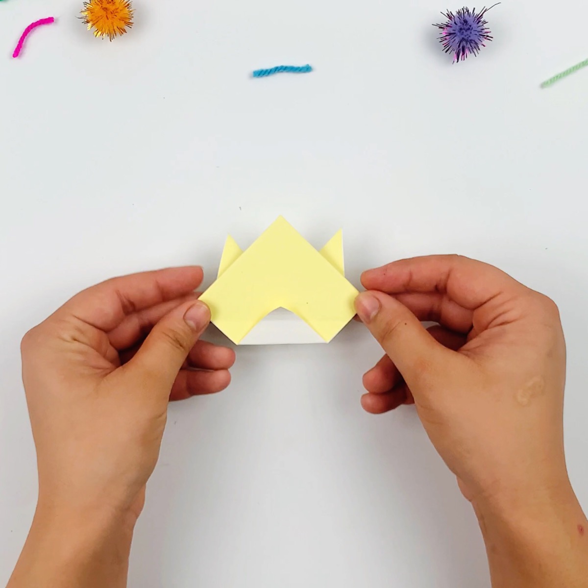 Flip the paper over and fold the bottom section a quarter of the way up. This will be where you draw the origami cat's mouth.