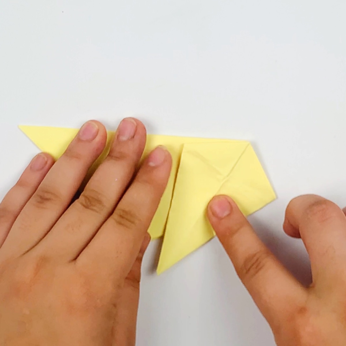 Flattening the fold of the origami cat tail section.