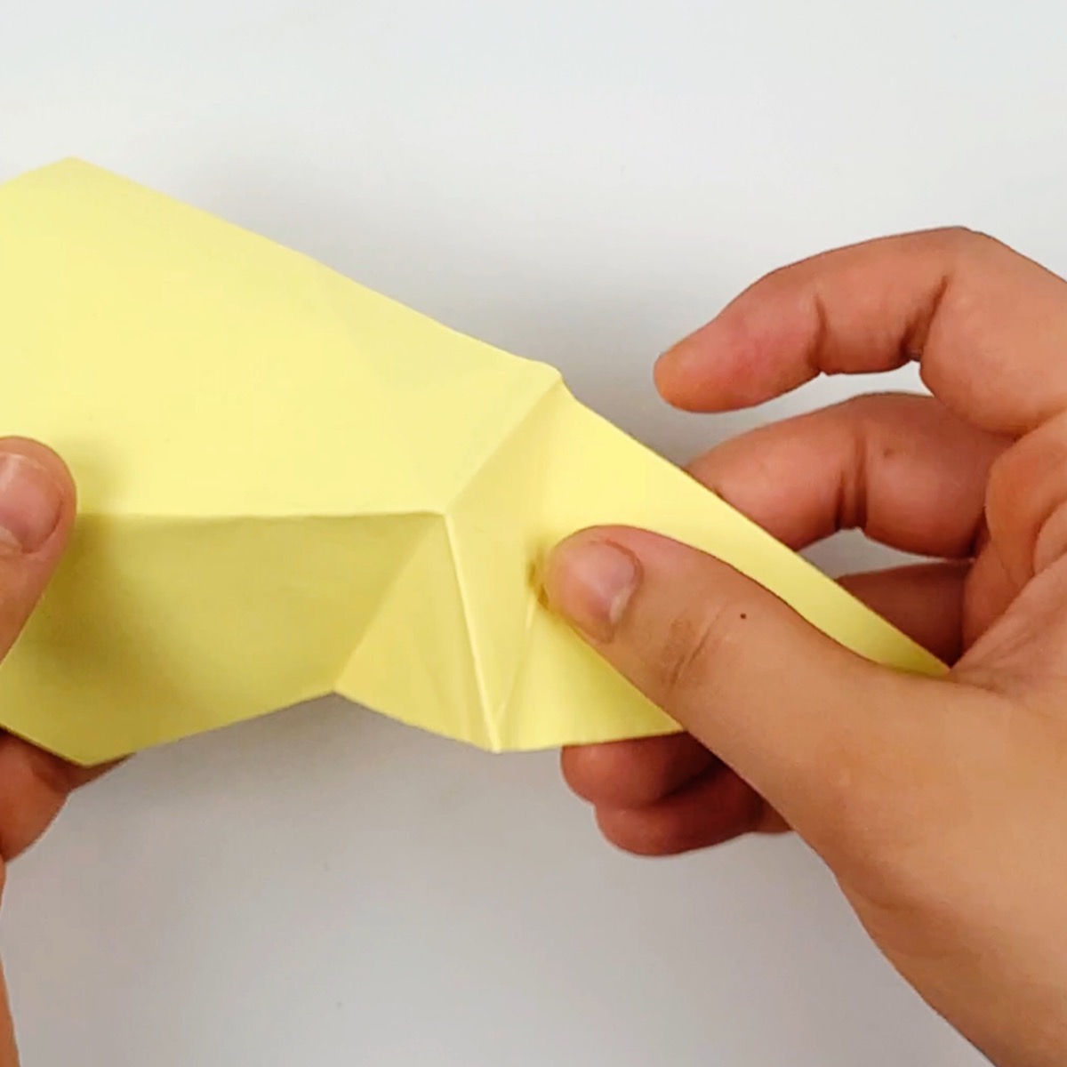 Pushing the fold in on itself to finish off the origami cat tail.