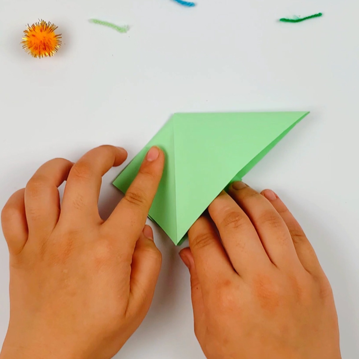 The origami fish is taking shape with some more folds made.