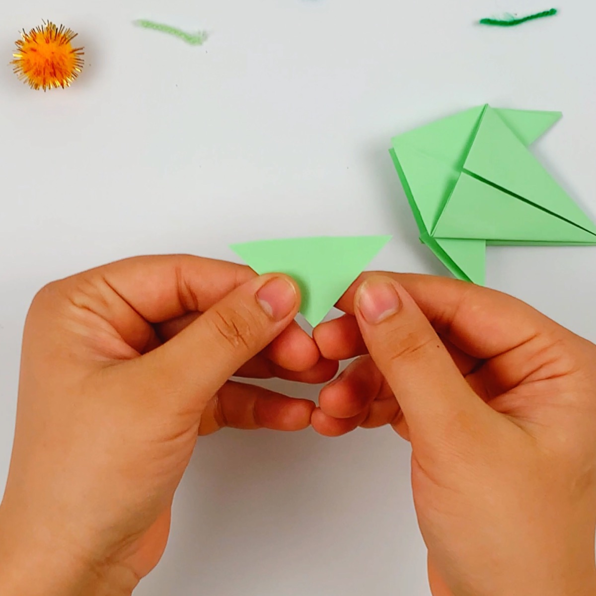 A seperate piece of triangular paper is used for the origami fish tail.