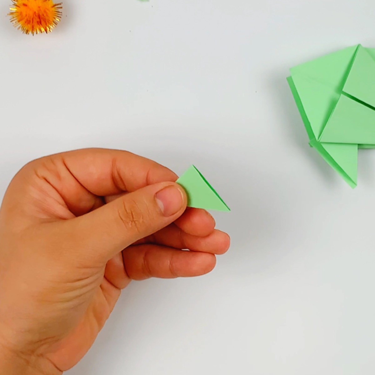 The origami fish tail is folded in half.