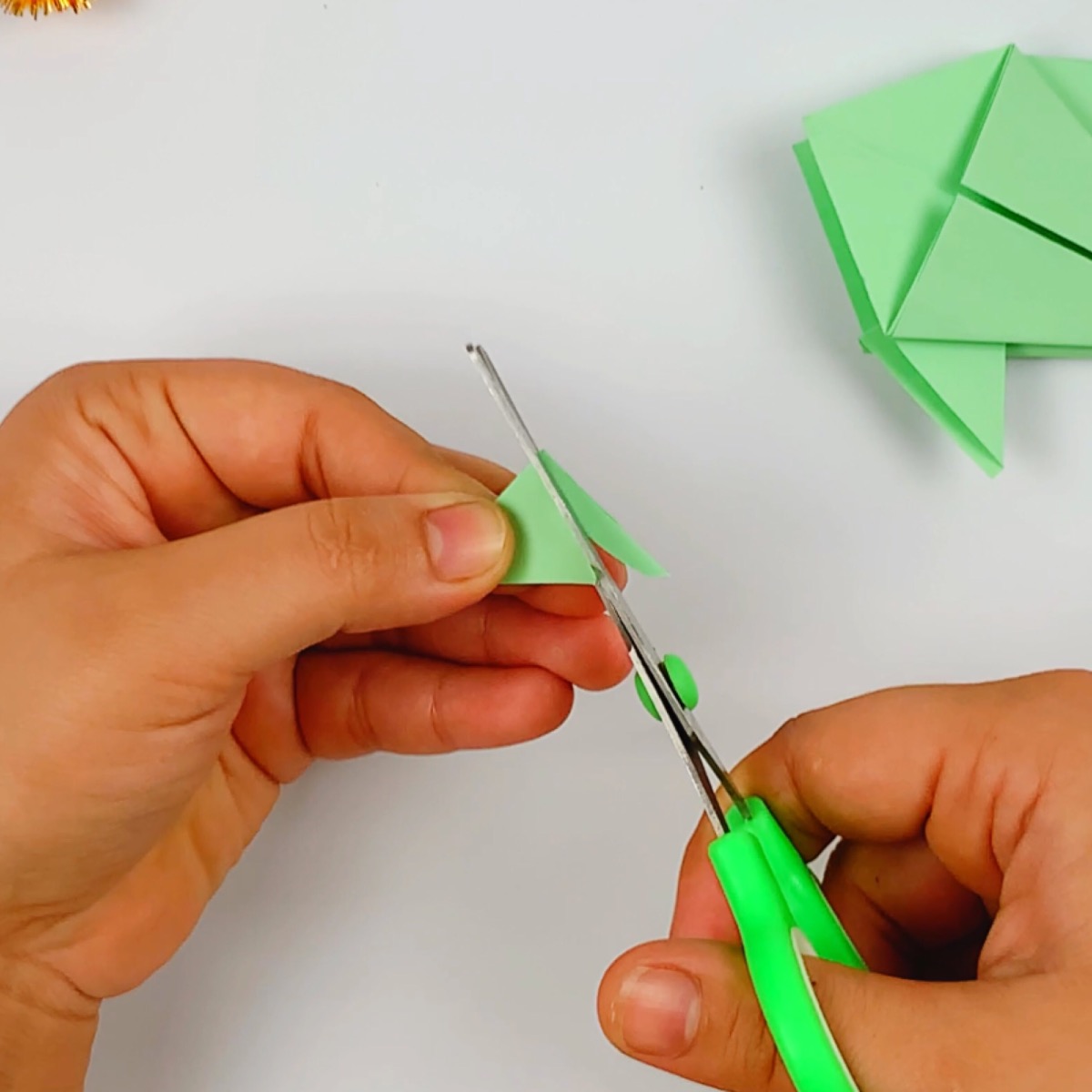 The origami fish tail is cut with a curvature to shape it properly.