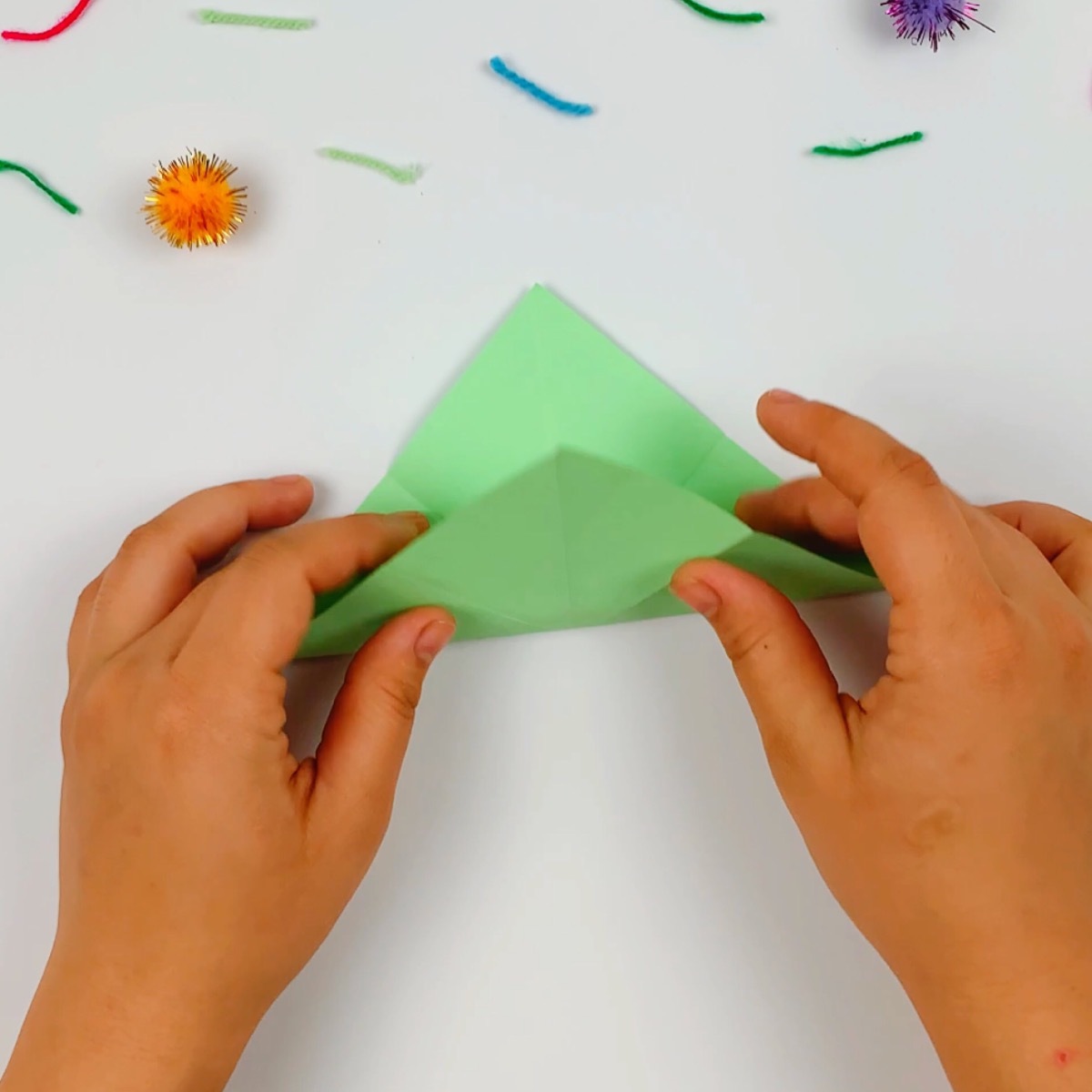 The square green paper is folded in triangle shape.