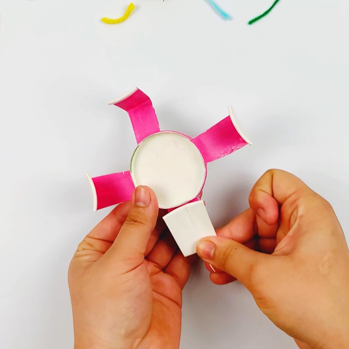 Folding the arms of the mechanical claw on the paper cup.
