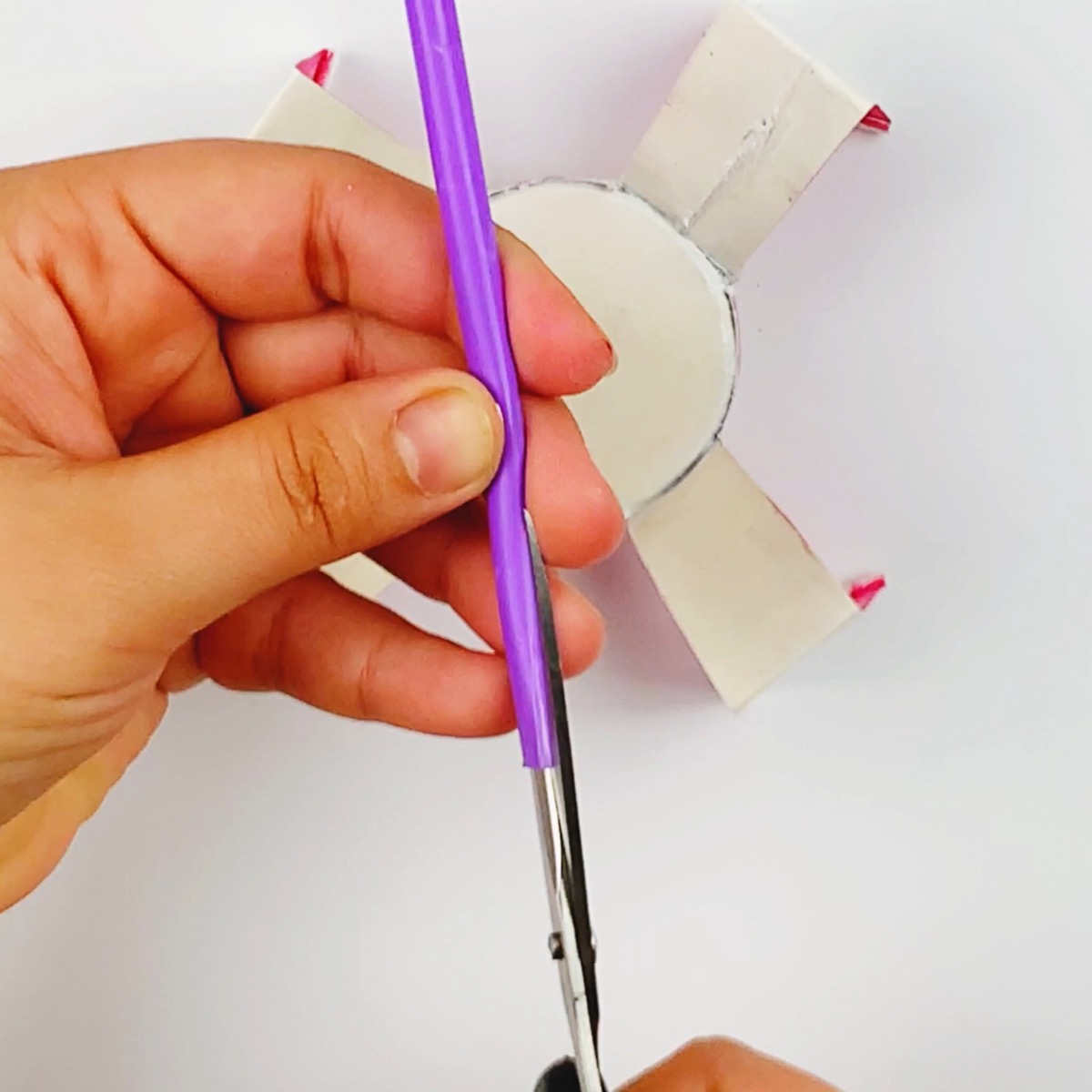 Cutting the straw so it can be glued.