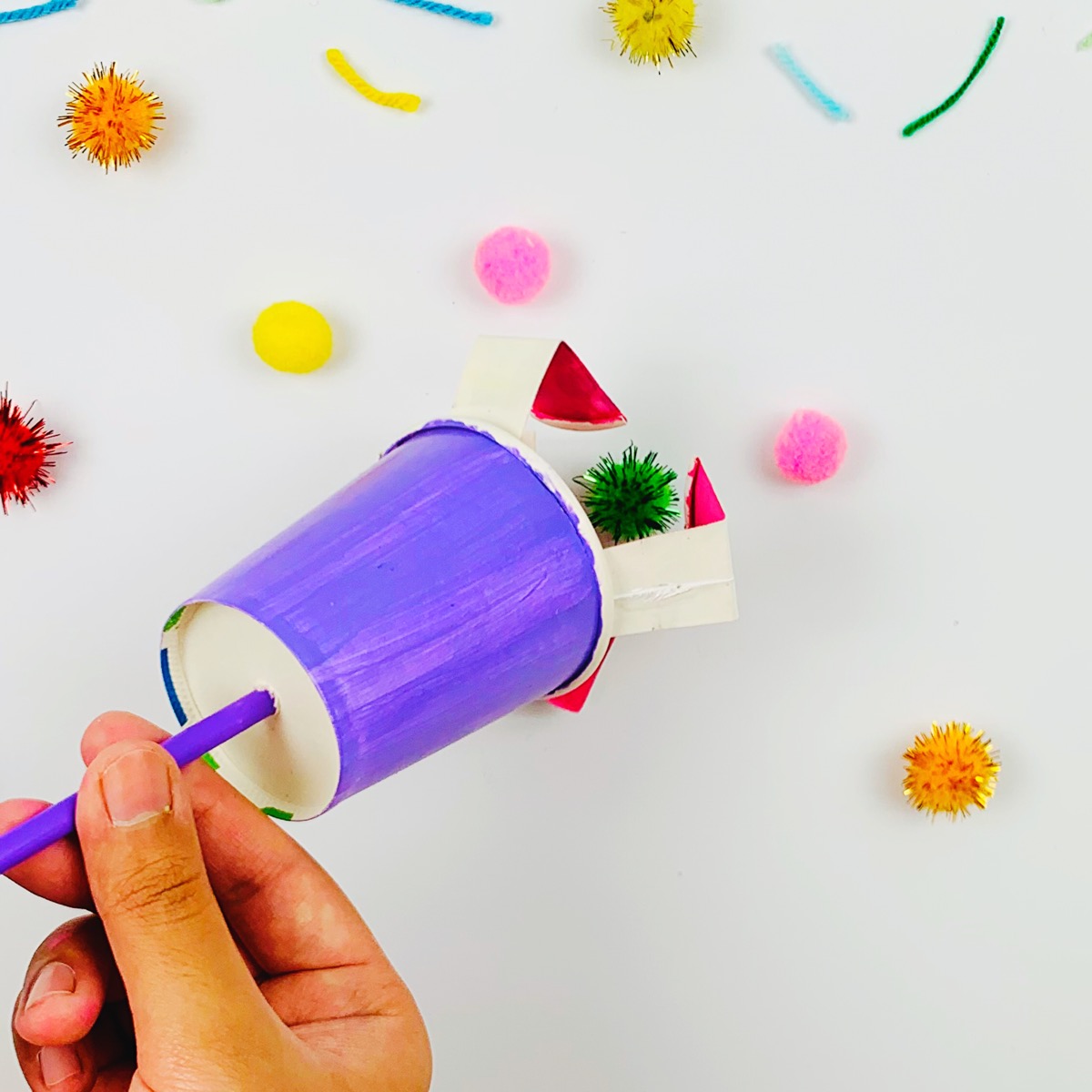 Using the paper cup mechanical claw to pick up items.