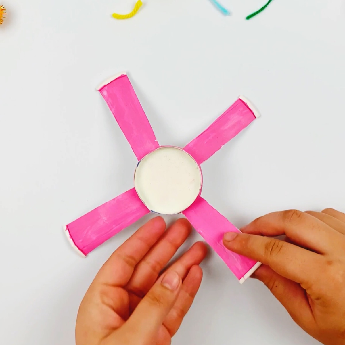 Folding the strips of the paper cup to form the arms of the mechanical claw.