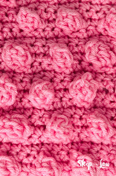 Pink yarn crocheted into a popcorn stitch.