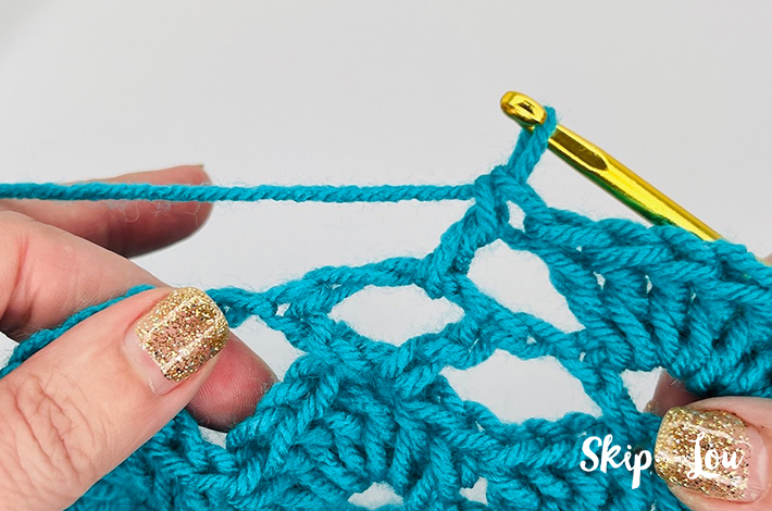 Blue colored yarn crochet in a shell stitch pattern.