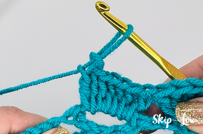 Blue colored yarn crochet in a shell stitch pattern.