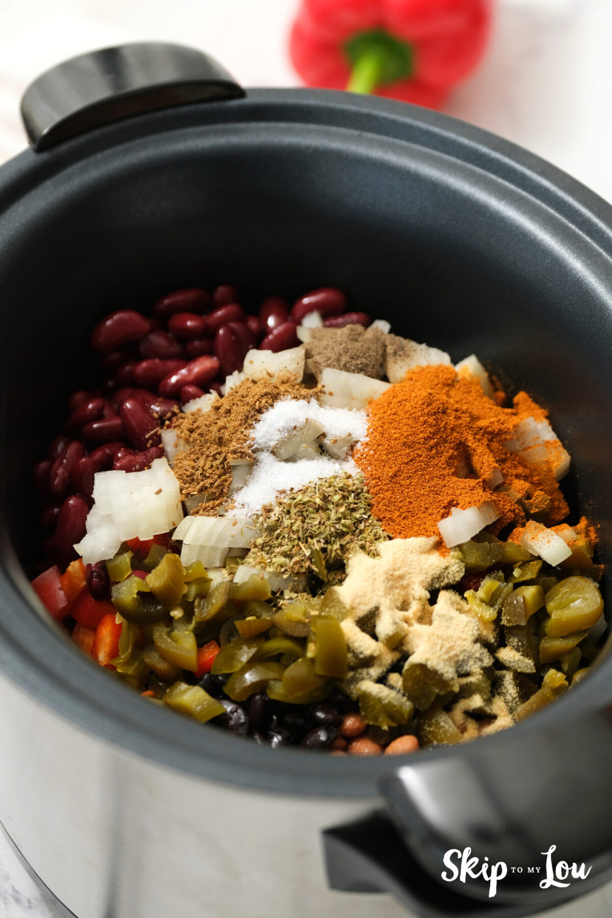 Once the beans are in the pot, spices such as chili powder, oregano, cumin, and salt and pepper are added.
