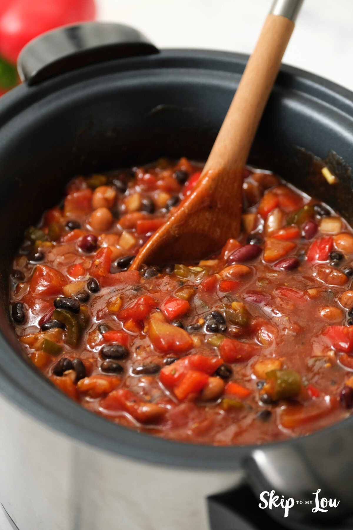 Following the addition of tomatoes, tomatoe sauce, and water, all the ingredients are mixed thoroughly.