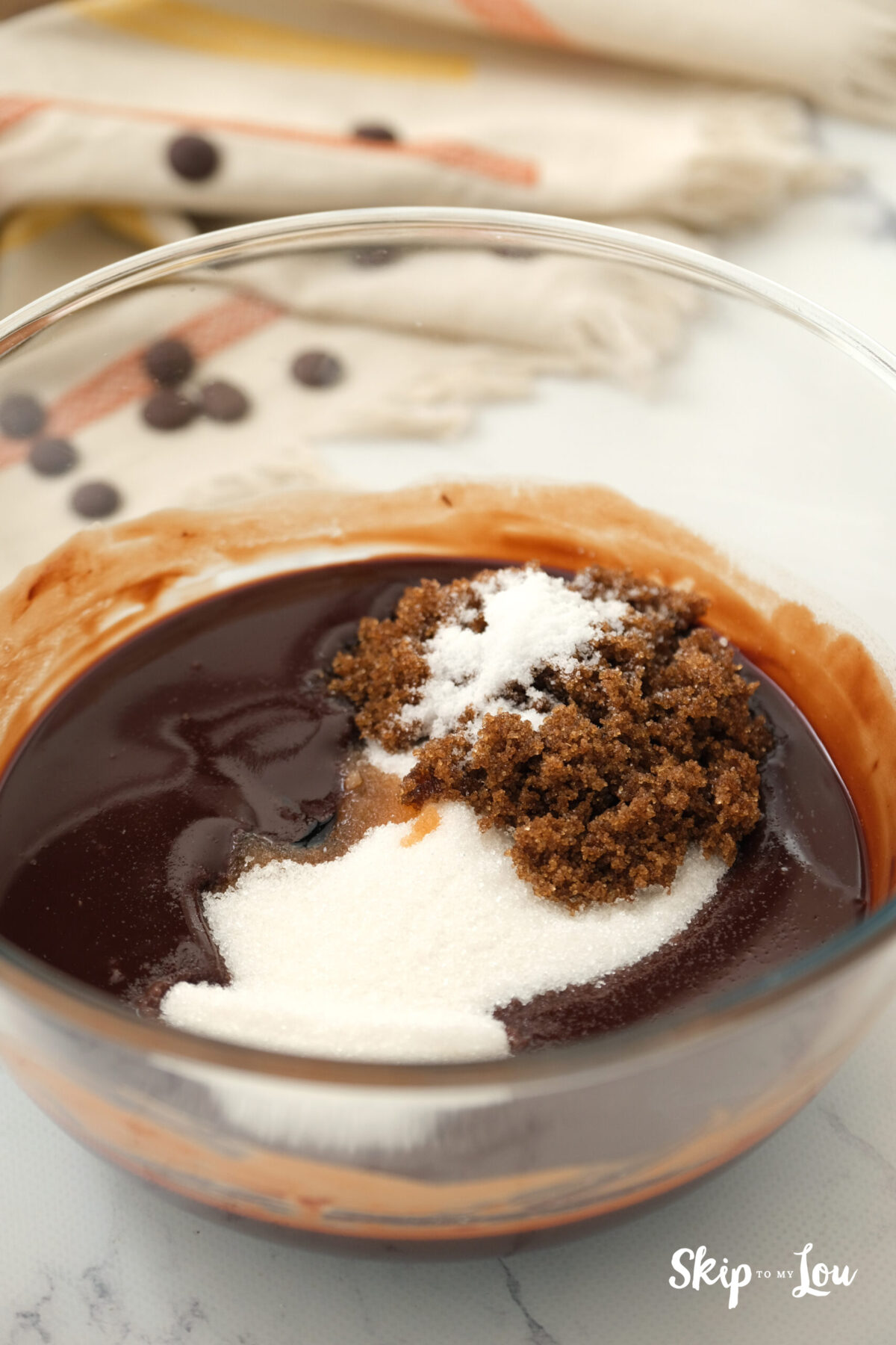 Sugar, brown sugar, salt and vanilla extract sitting on top of the mixture in a bowl. 