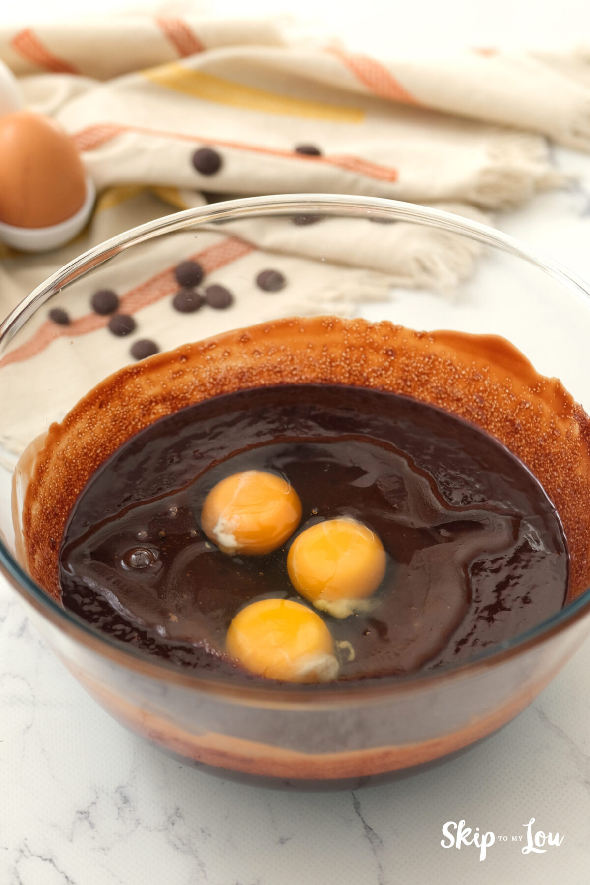 Eggs sitting on top of the batter in a bowl. 