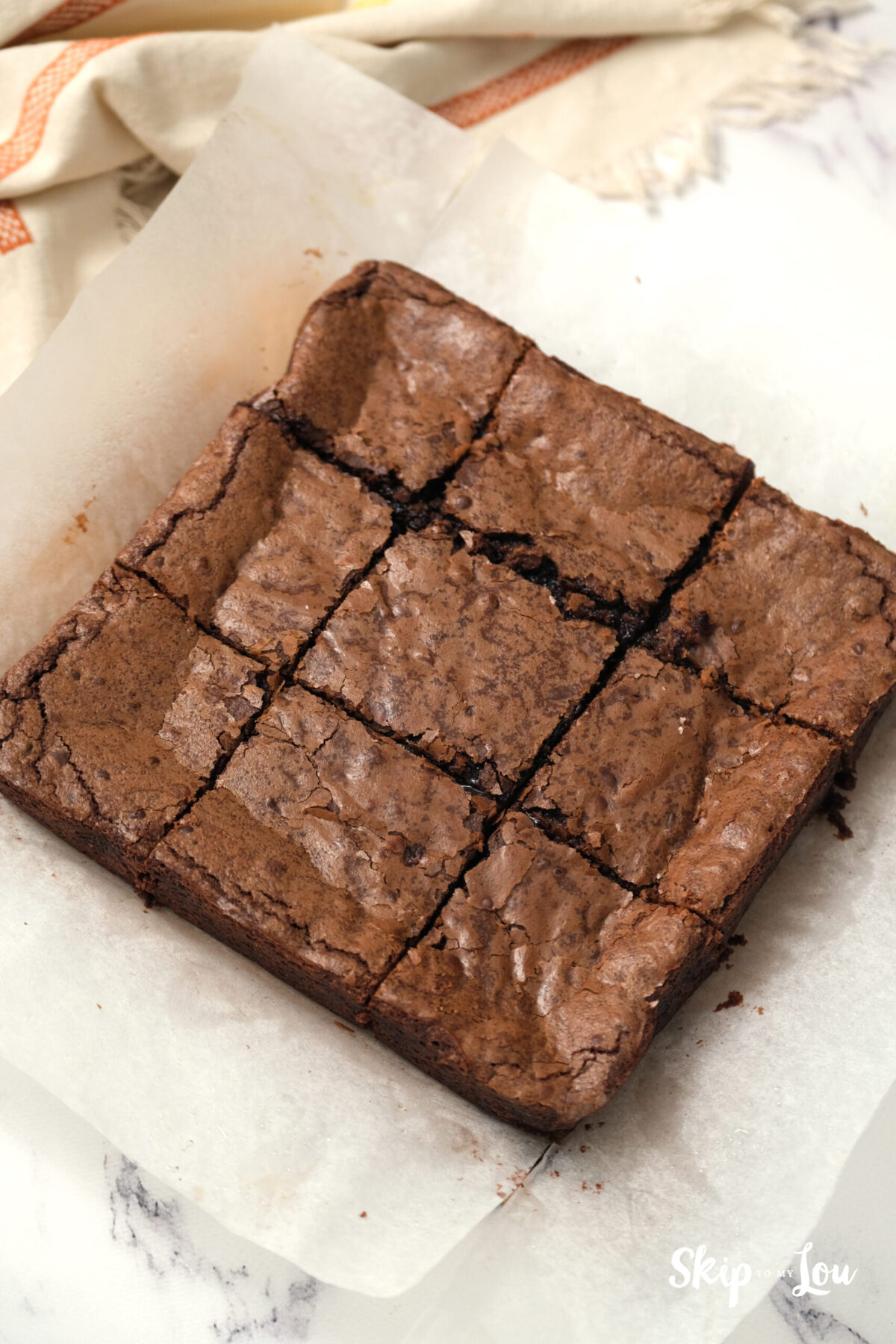 Baked brownies on partchment paper cut into squares