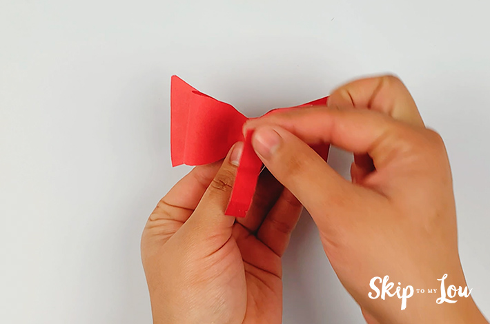 Thin piece of paper is cut and placed in the middle of the bow tie.