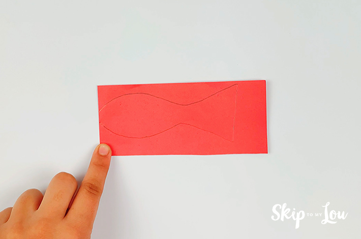 A completed fish outline drawn on a red piece of rectangulr paper.