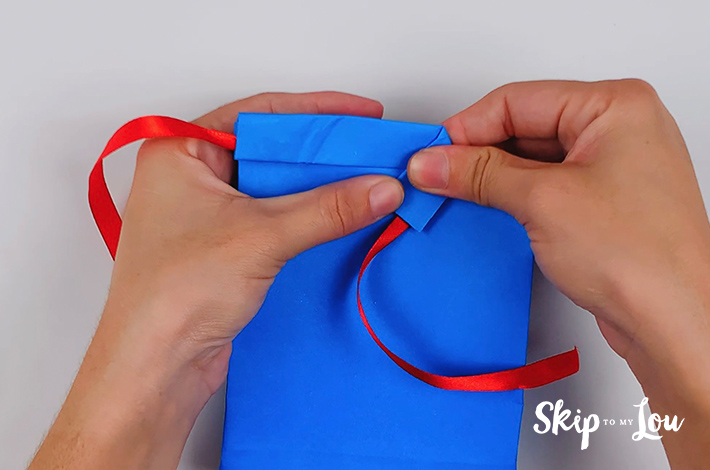 The glued sections are folded over to form the collars of the origami shirt and tie. 