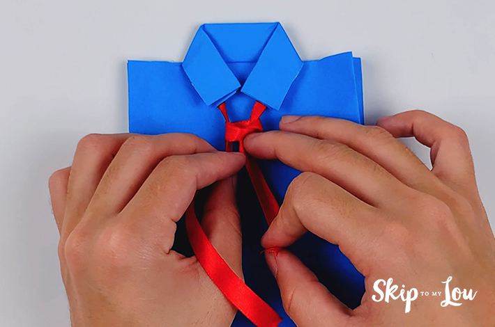 A knot is made in the ribbon to form the tie. 