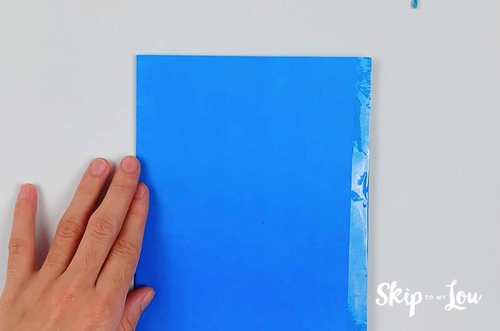 Blue paper folded in half and stuck with clear tape on one side.