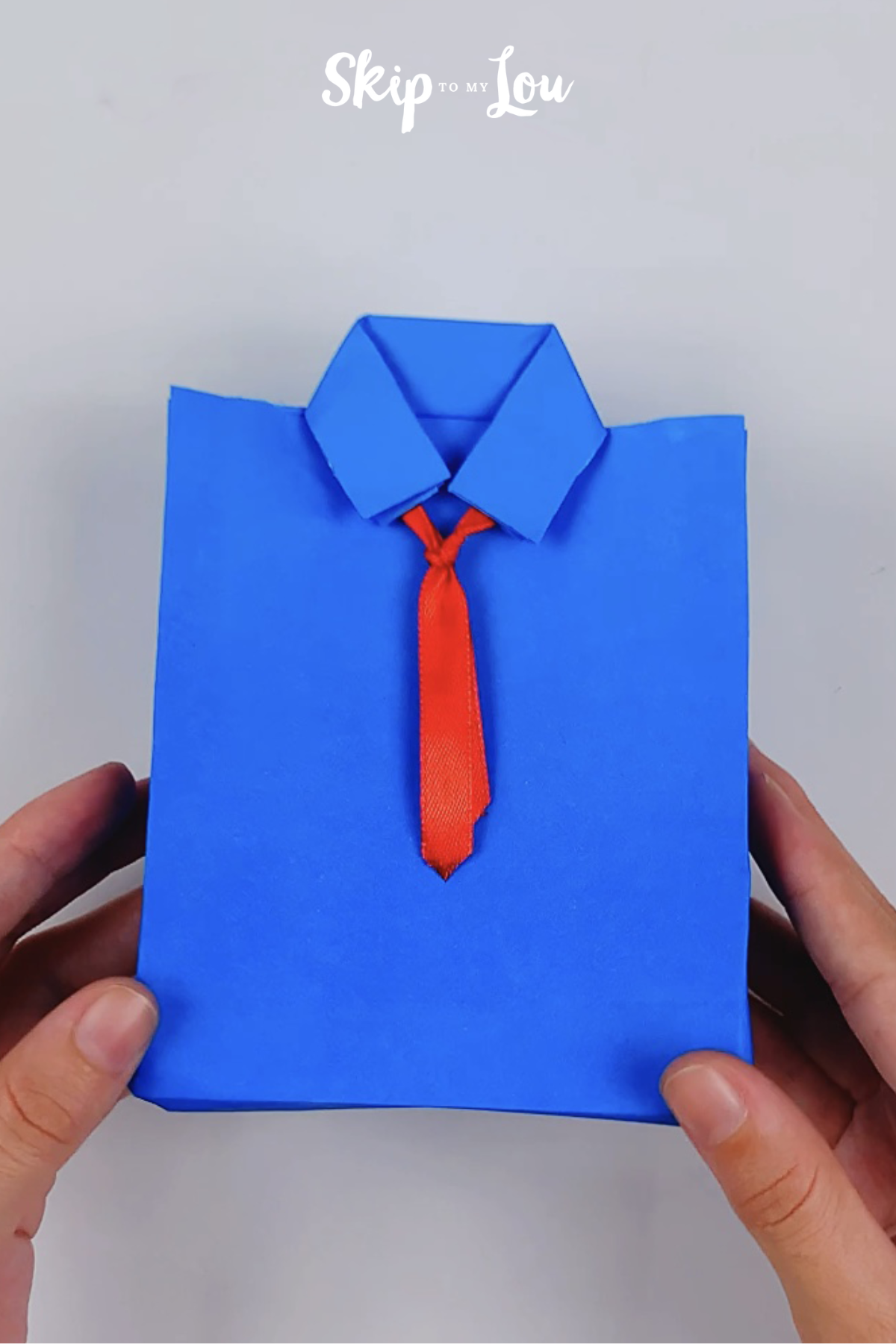 A blue folded origami shirt with a red ribbon tie from skip to my lou