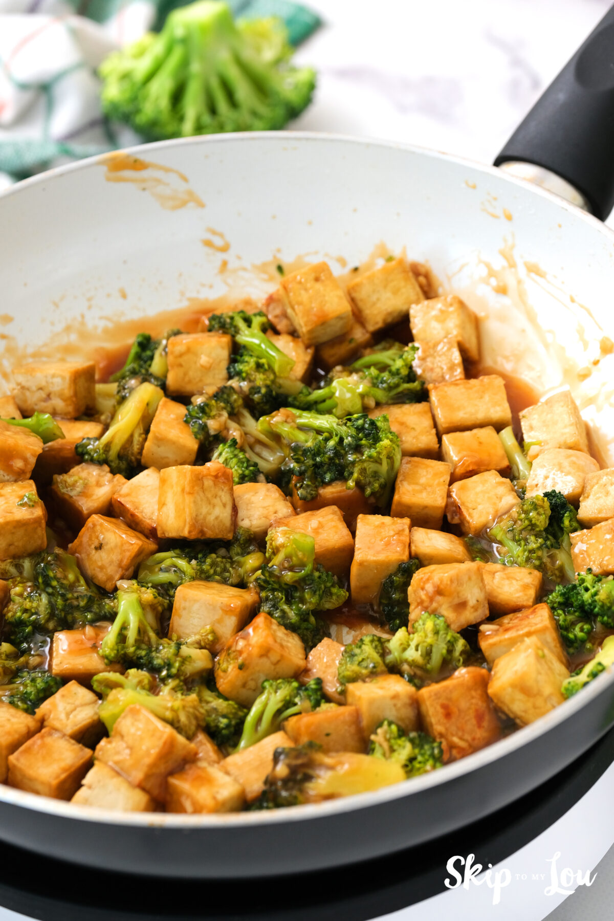 A pan with tofu cubes added to the broccoli and sauce mixture. 
