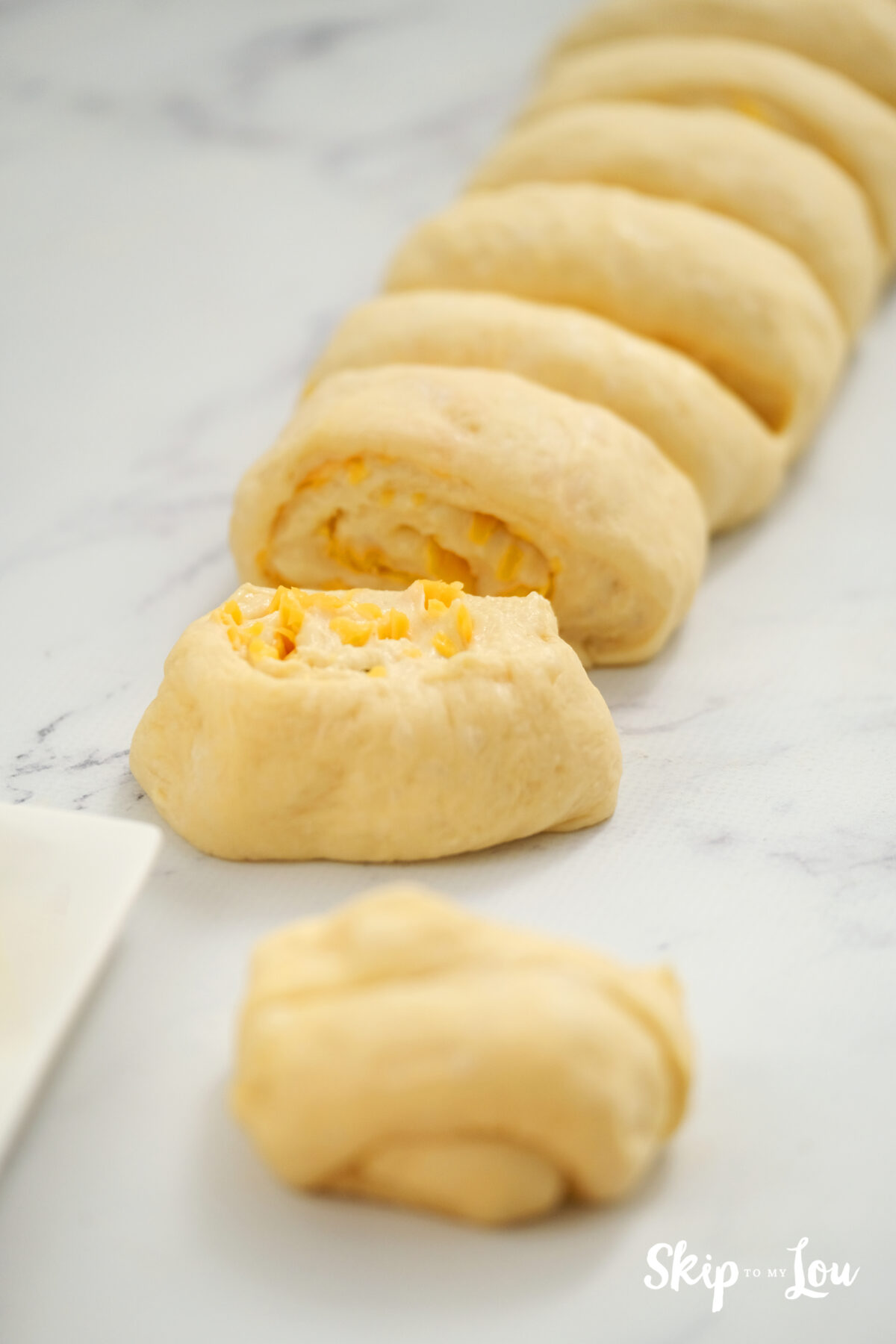 The dough being sliced into individual disks.
