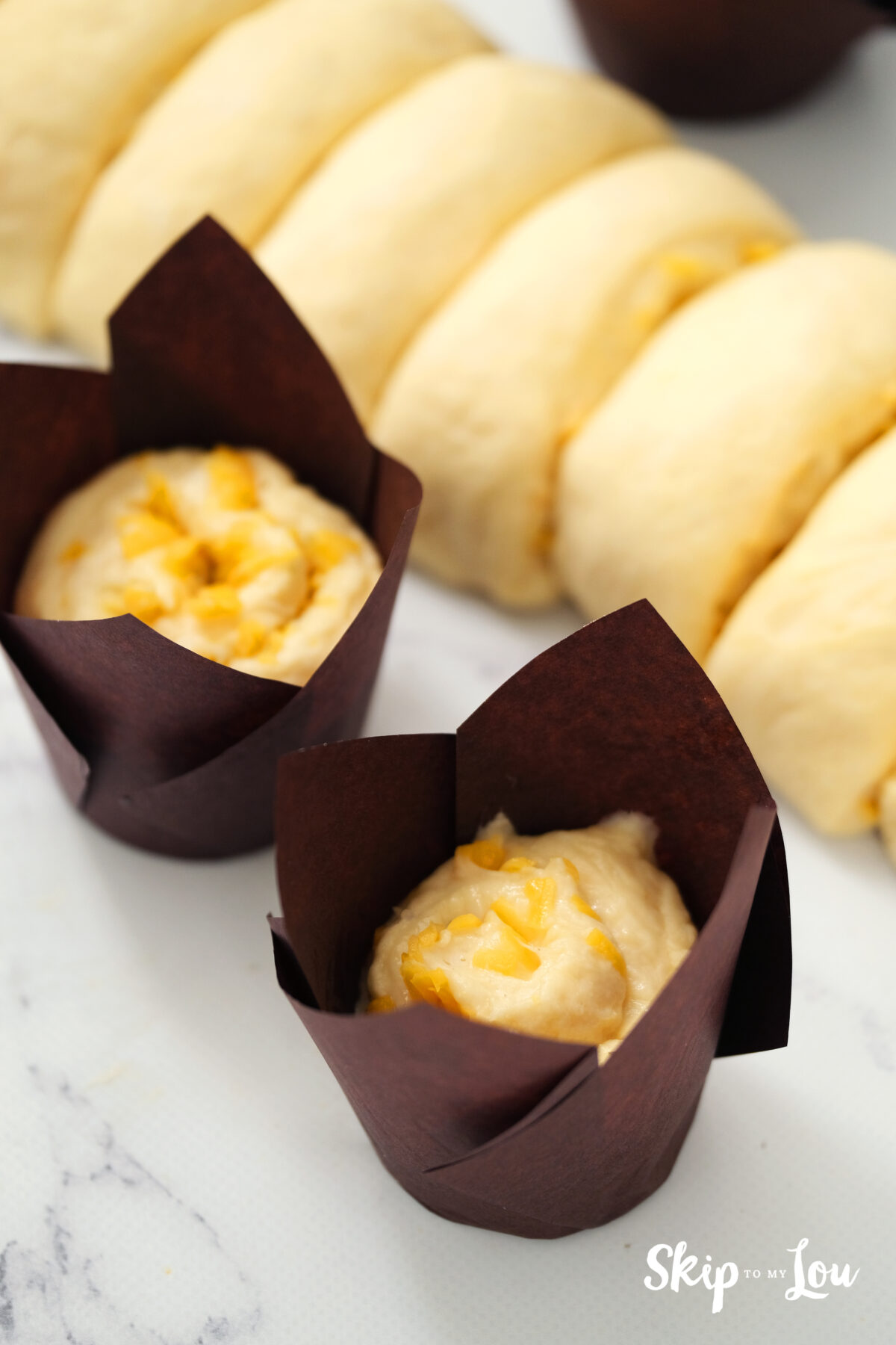 A muffin cup with a dough disk placed inside.