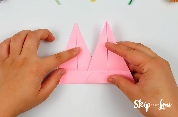 Two hands placing the second spike on the glued area.