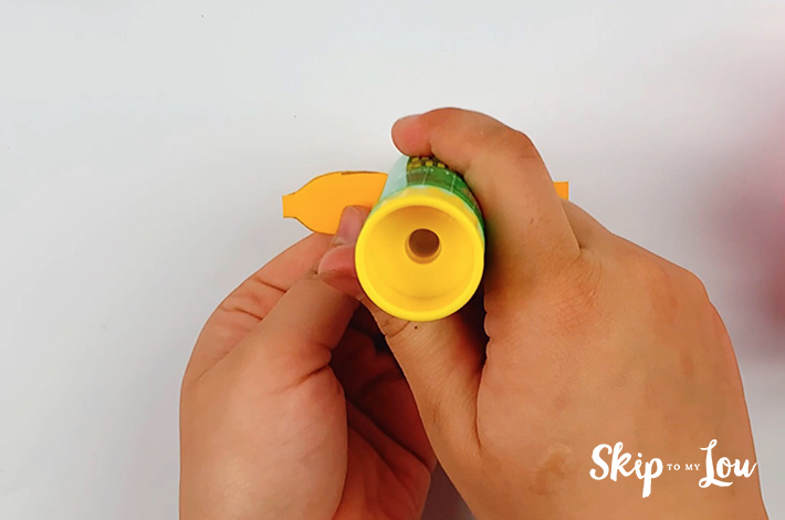 Two hands adding some glue to the center of the paper.