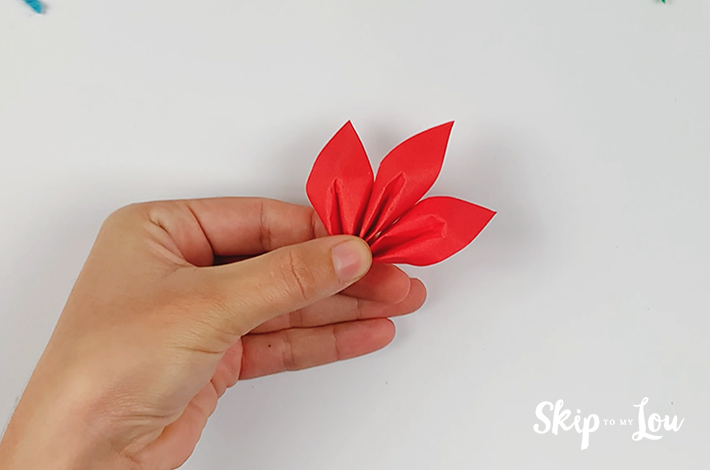 A hand holding three finished petals.