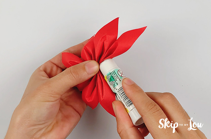 A hand glueing the petals together.