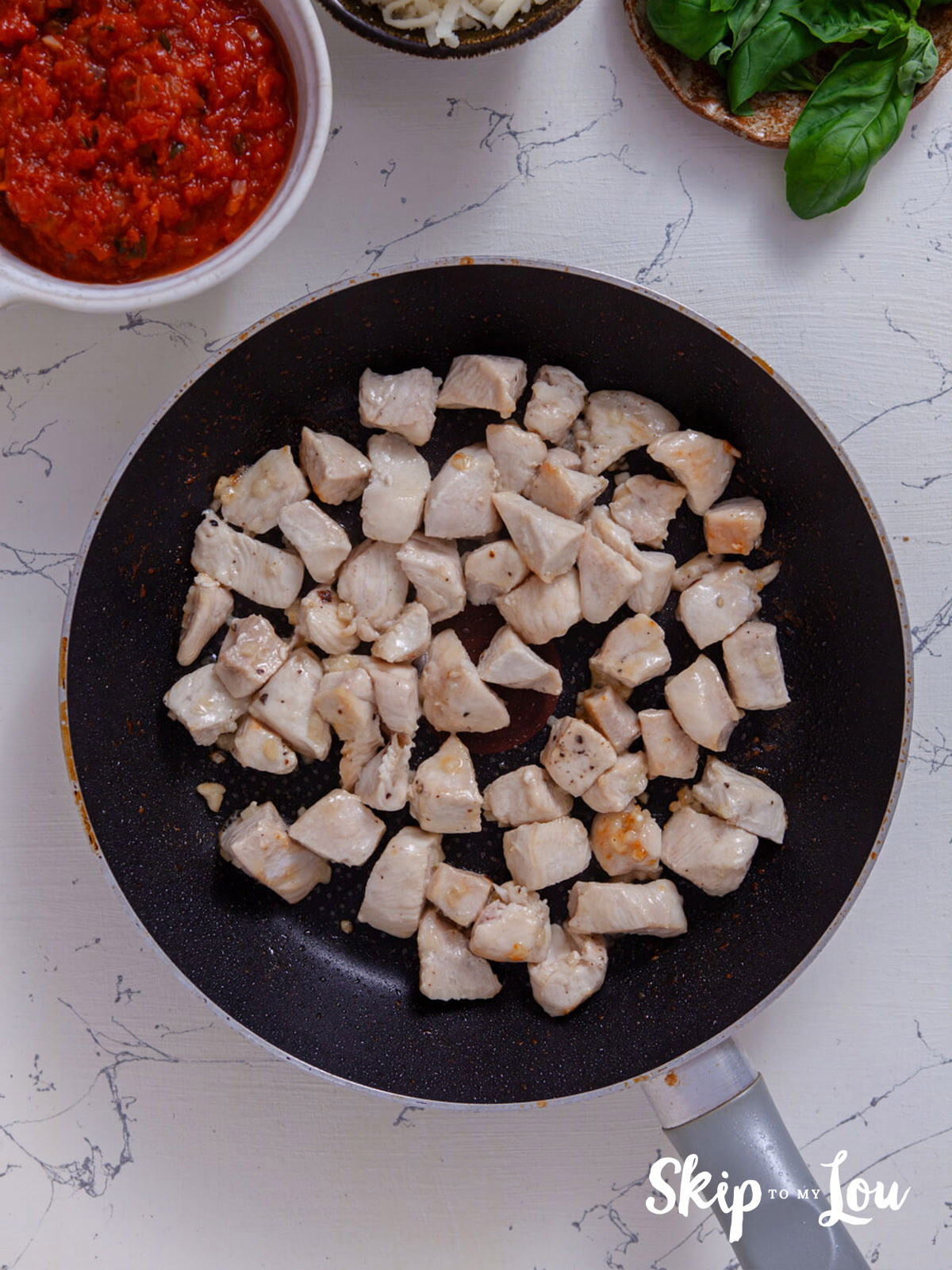 Chicken frying in a skillet.