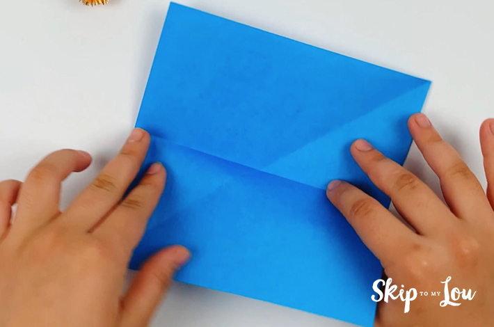 Two hands turning the paper 90 degrees.