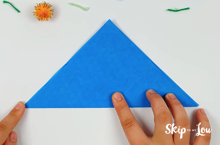 Two hands forming a triangle from the folds just made.