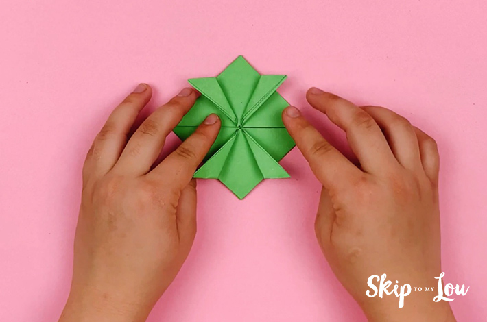 Two hands showing the completed folds. 